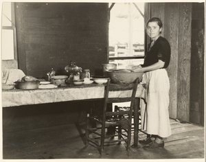 [Elizabeth Tengle aan de keukentafel]/[Paralee Ricketts aan het werk in de keuken].