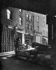 Fruitmanden opgestapeld tegen huizen op Borough Market, Londen, 1926-1927