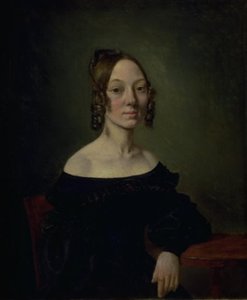 Portret van een meisje in een zwarte jurk zittend aan tafel