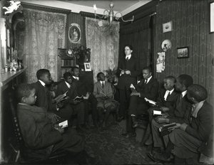 Evangelistencomitéles bij mevrouw Bostick, 72 West 99th Street, de heer Rockwood geeft les aan een groep jonge Afro-Amerikaanse mannen en jongens. 31 maart 1916 door William Davis Hassler