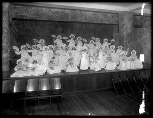Groep kleine meisjes geposeerd op een klein podium met waaiers, waarschijnlijk het Rooms-Katholieke Weeshuis, Kingsbridge, Bronx, ca. 1911