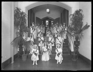 Kleine meisjes in het Rooms-Katholieke Weeshuis, Kingsbridge, Bronx, terugkomend van de kapel in witte jurken met kransen en slingers, 20 oktober 1914