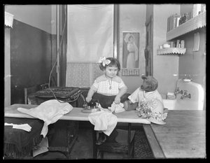 Onbekend klein meisje demonstreert het gebruik van een elektrische strijkijzer, c.1913-14
