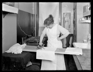 Onbekende vrouw die het gebruik van een elektrisch strijkijzer demonstreert ca. 1913-14