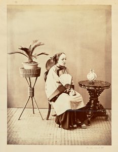[Studioportret van een zittende jonge vrouw met een waaier]. door William Saunders