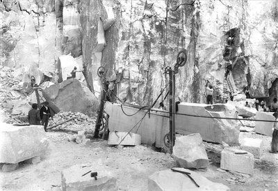 Gravers aan het werk in een marmergroeve in de Apuane Alpen, Toscane. Op de voorgrond zijn blokken marmer al vierkant gemaakt. door A. Corsini