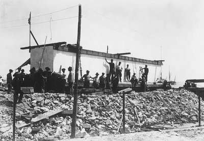 Verschillende mannen rond een enorm marmerblok, net getransporteerd naar de vallei vanuit de steengroeven in de Apuaanse Alpen door A. Corsini