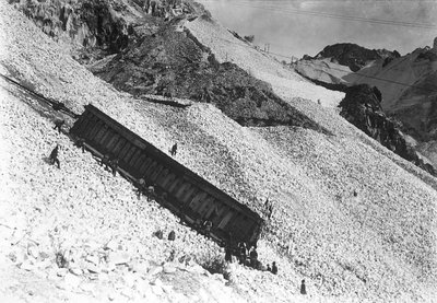 Transport van een enorm konvooi met marmer, langs de kliffen bij een groeve in de Apuanische Alpen, Toscane (zw/w foto) door A. Corsini