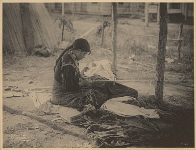 [Vrouw van de Meskwaki Natie bezig met kralenwerk].
 door Adolph F. Muhr