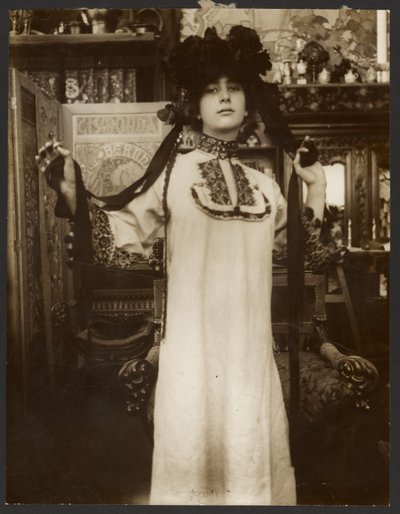 [Vrouwelijk model in een lang wit gewaad en een hoed met linten, Parijs]. door Alphonse Maria Mucha
