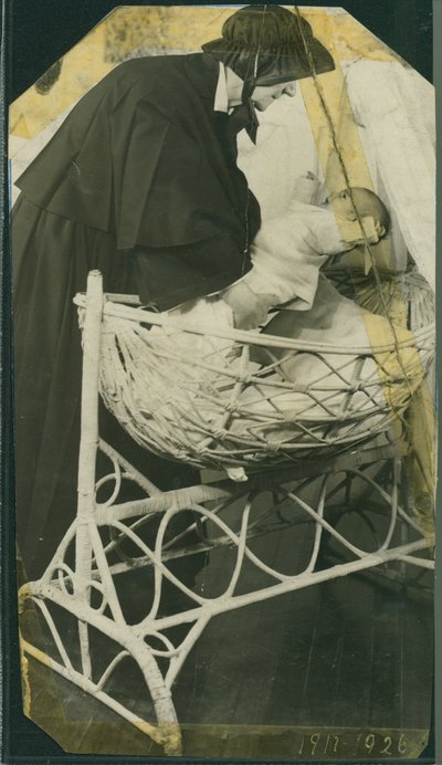 New York Foundling Hospital - Zuster Anna Michella met baby en wieg door American Photographer