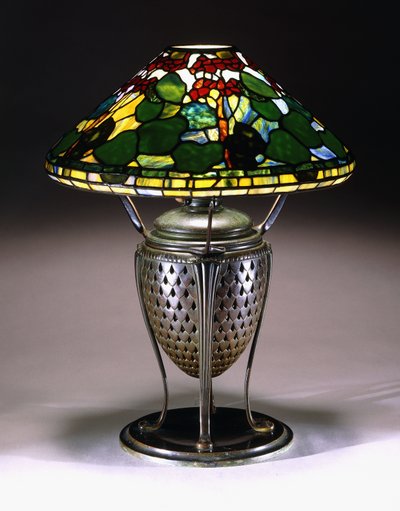 Een "Geranium" tafellamp met een conische kap, en geperforeerde bronzen urnvoet met een visschubbenpatroon, 20e eeuw door American School