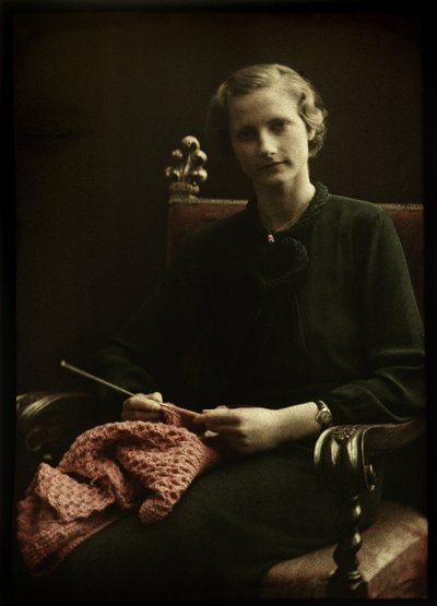 Portret van een vrouw, zittend in een stoel, met breiwerk in de hand door Anonymous