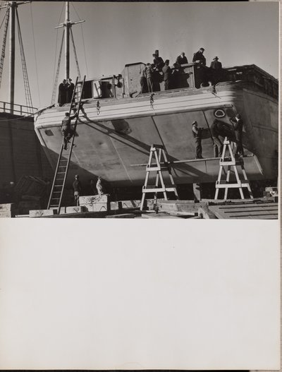 [Een groep mannen werkt aan een aangemeerde boot]. door Arnold Eagle