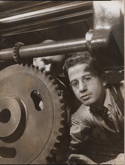 [Close-up van een man die met een groot tandwiel werkt]. door Arnold Eagle