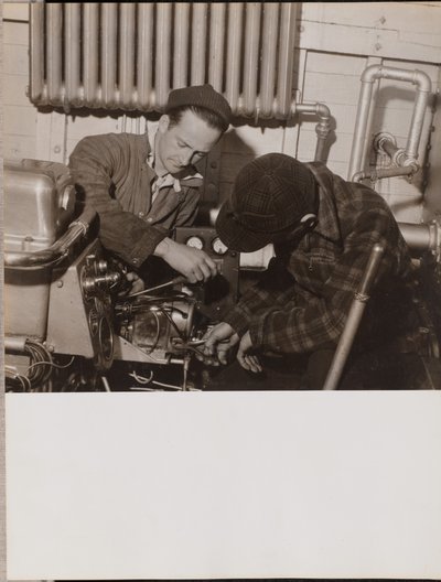 [Twee mannen werken aan een machine met een schroevendraaier en een moersleutel]. door Arnold Eagle