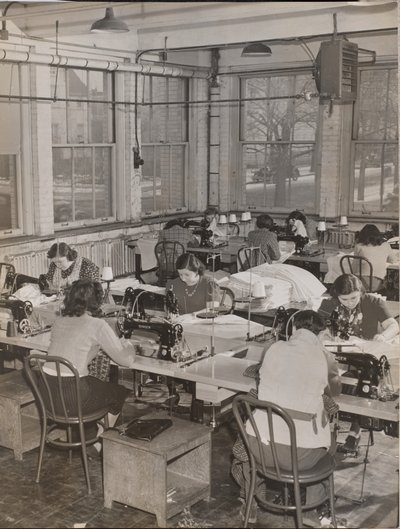 [Vrouwen aan bureaus werken aan naaimachines]. door Arnold Eagle