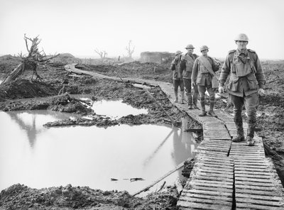 Vier Australische soldaten die over het eendenbordpad bij Tokio, nabij Zonnebeke, in de Ypres sector, lopen over een deel van het land dat door de Australiërs is veroverd in de gevechten van de Derde Slag door Australian Photographer