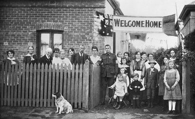 Groepsportret van 540 Sapper Arthur Findon Dunbar MM, 2e Australische Tunneling Company (in uniform met zijn arm rustend op een poort) en zijn familieleden verzameld buiten hun huis aan Chief Street 45 door Australian Photographer