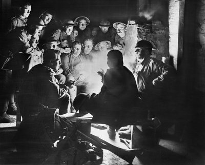 Leden van de 1st Australian Light Trench Mortar Battery, 1st Australian Division luisteren naar het laatste nieuws van een van hun kameraden rond een vuur in een schuilplaats bij Ypres, 28 oktober 1917 door Australian Photographer