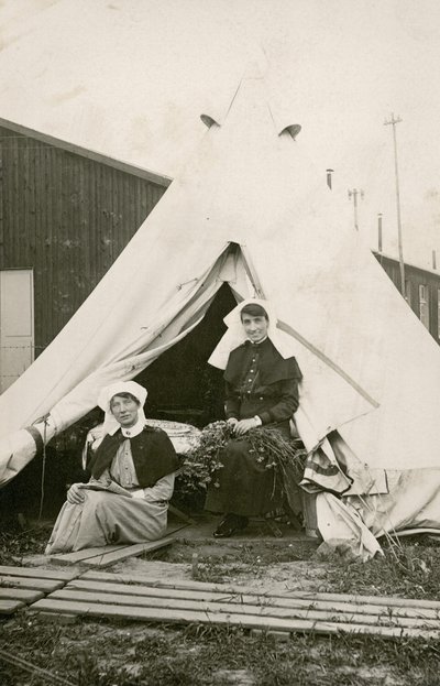 Zuster Eleanor Wibmer Jeffries en zuster Nellie Constance Morrice (rechts) buiten hun tent bij het 3e Australische Algemeen Ziekenhuis met bloemen geplukt van de oever van de Somme, c. juni 1917 door Australian Photographer