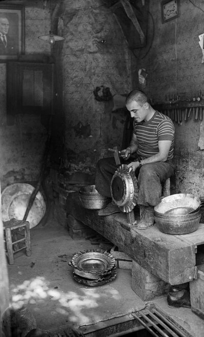 Italiaanse metaalbewerker hamert op een vormplaat om een verhoogd vat of pot te maken, Italië door Bernard F. Rogers