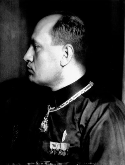 Halflang portret in profiel van Benito Mussolini in zwart shirt en militaire onderscheidingen door Brogi Brogi