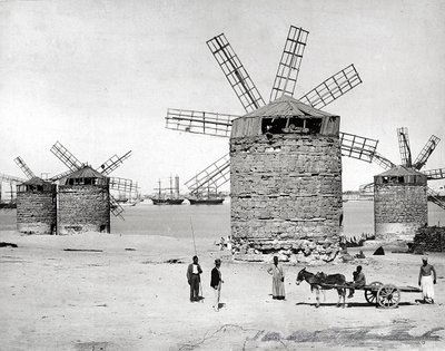 Windmolens aan de Middellandse Zee in Alexandrië, Egypte. Op de voorgrond poseren enkele Egyptenaren met een kleine kar door Brothers Zangaki