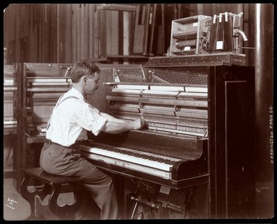 Een man aan het werk in de Harrington Piano Co. fabriek, 1907 door Byron Company