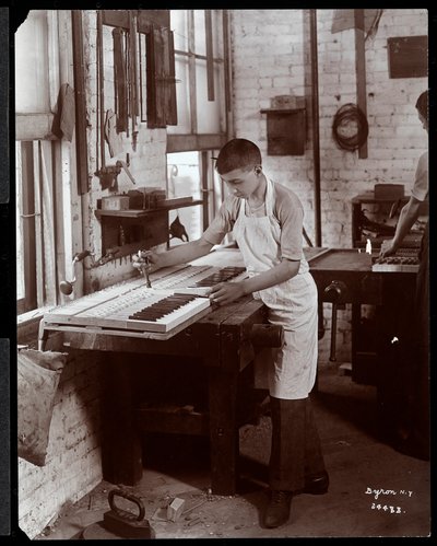 Een jonge man die werkt in de fabriek van Harrington Piano Co., 1907 (zilveren gelatin print) door Byron Company