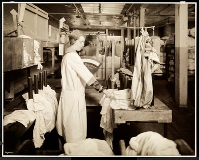 Vrouwen labelen zakken wasgoed bij de Carolyn Laundry op 111 East 128th Street, East Harlem, New York, 1928 door Byron Company