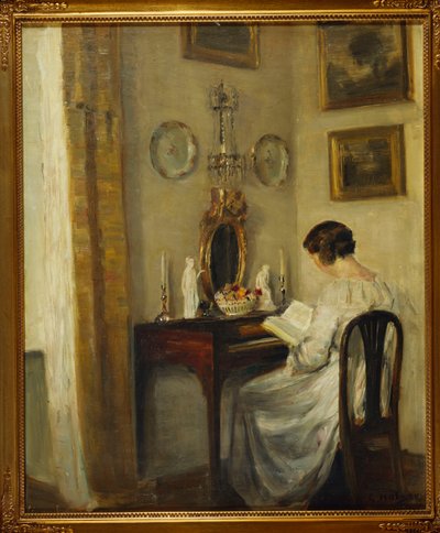 Een interieur met een meisje dat leest aan een bureau door Carl Holsoe