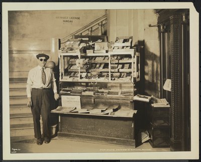 Blinde krantenverkoper, John Martie, bij zijn stand aan het zuideinde van het gemeentelijk gebouw, New York door Company Byron