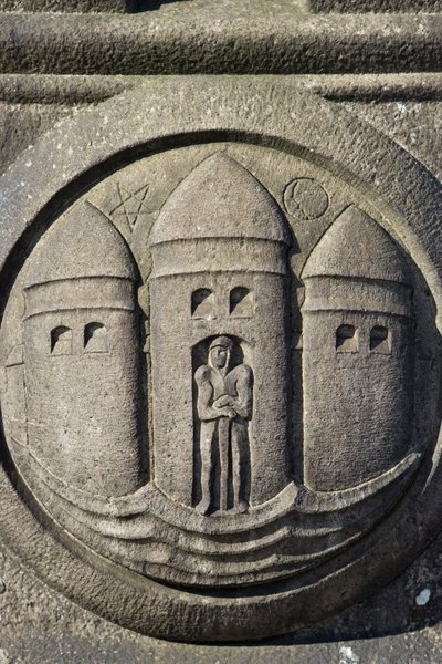 Drie torens symbool uitgehouwen in een stenen kolom op het Stadhuisplein door Danish School