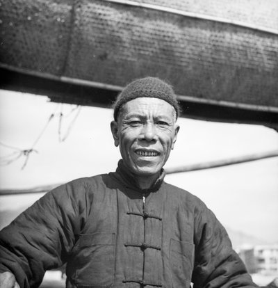 Een portret van een van de bemanningsleden van een Canton zoutschuit aan boord van zijn schip in Sham Shui Po, Hong Kong door David Watkin Waters