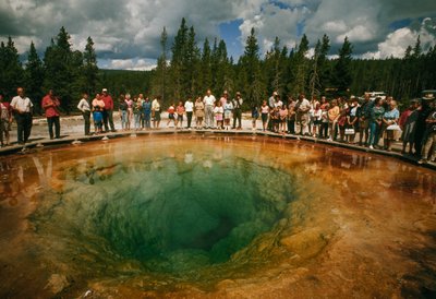 Parkbezoekers verzamelen zich rond blauwgroene, bloemvormige thermale poel. Yellowstone National Park. door Dean Conger
