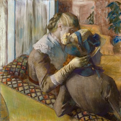 Bij de modeontwerper. Een klant die een hoed probeert door Edgar Degas