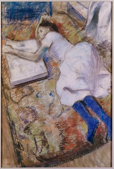 Jong meisje uitgestrekt kijkend naar een album, ca.1889 door Edgar Degas
