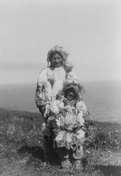 Een jong kind en een oudere Eskimo met eendenhuid parka