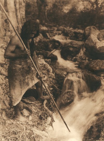 Jonge Amerikaanse Indiaan van de Hupa stam die zalm vist met een lange stok door Edward Sheriff Curtis
