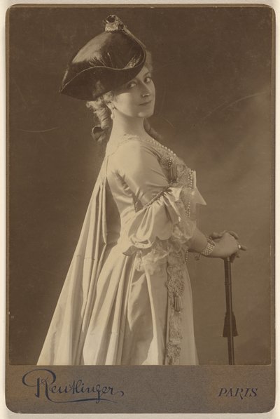 [Ongeïdentificeerde vrouw met donkere hoed, staand, met de handen rustend op een wandelstok]. door Emile Auguste Reutlinger
