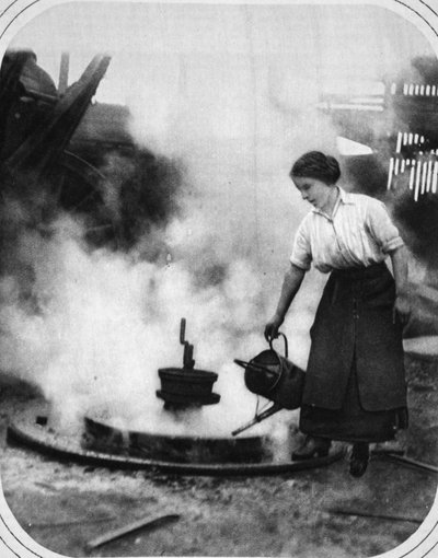 Een behulpzame hand in oorlogstijd: Miss Edith Hawley die een wiel afkoelt door English Photographer