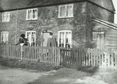 Een landelijk tafereel in de omgeving van Wandsworth met een ouder echtpaar in de tuin van een huis in cottage-stijl, Londen, 1895 door English Photographer
