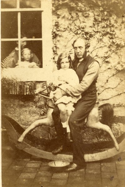 Vader en dochter zittend op een hobbelpaard met broer en moeder kijkend door het raam, 1860s door English Photographer