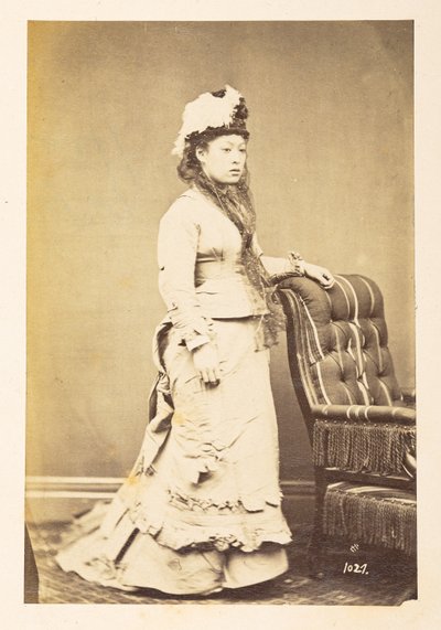 Japanse vrouw in Europese kleding, Volledig staand studiportret van een jonge Japanse vrouw in westerse kleding en hoed, Fotograaf: Onbekend Lucas Collectie: Fotografisch verslag van de wereldreis van Charles James en Morton P, Lucas door English Photographer