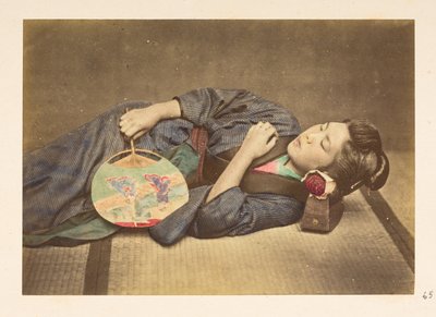 Japanse vrouw slapend, Driekwart lengte studiportret van een jonge Japanse vrouw slapend, met een waaier in haar rechterhand en haar hoofd rustend op een houten kussen, Fotograaf: Onbekend Lucas Collectie: Fotografisch verslag van de wereldreis van Charles door English Photographer