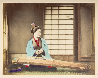 Zingende meisjes [Japan], Studioportret van een Japanse vrouw, zittend met een snaarinstrument (een soort citer) voor haar op de grond door English Photographer