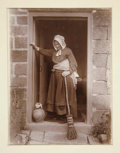 Een oude dame met een gistfles bij een cottage deur door Frank Meadow Sutcliffe