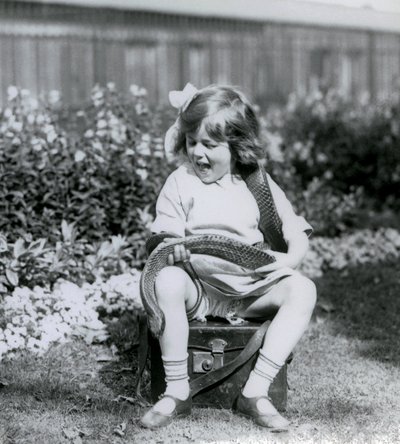 Een jong meisje Betty houdt een oostelijke indigo-slang vast terwijl ze op een leren koffer zit, London Zoo, 1924 door Frederick William Bond