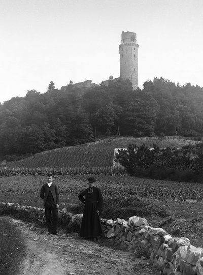 De dorpspastoor, vergezeld door een jonge man, poserend op de weg voor de toren van Montlhery in de Essone. Fotografie eind 19e eeuw. Ducos Collectie door French Photographer